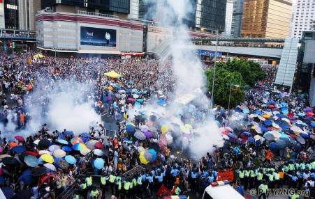 Protestors use umbrellas to protect themselves against pepper spray attacks made by police early on in the demonstration. Credit: PH Yang